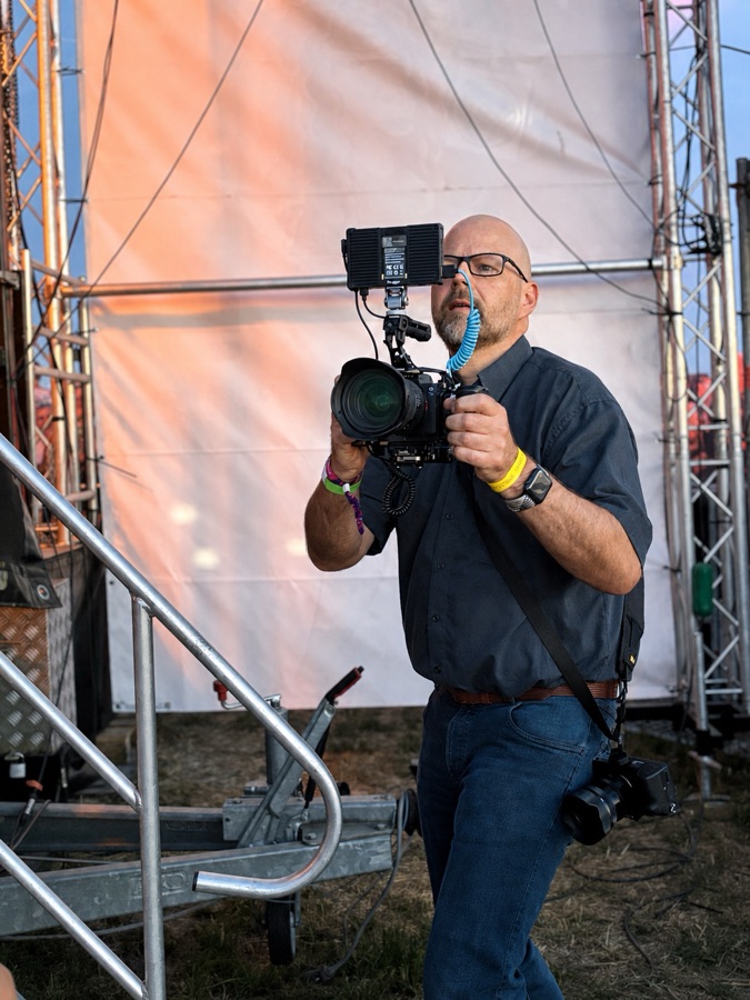 Kameramann Bodo Kern mit Kamera-Rig im Abendlicht auf einem Open-Air-Gelände – Videoproduktion Hannover
