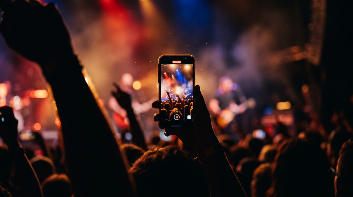 Symbolbild Social-Media-Content: Smartphone filmt Konzert (KI-generiert)